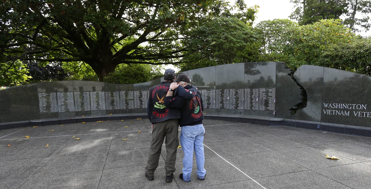 Bob Logan, left, of Rainier hugs Allen Arthur at the Washington State Vietnam Veterans Memorial in Olympia after a National POW/MIA Recognition Day ceremony Friday.