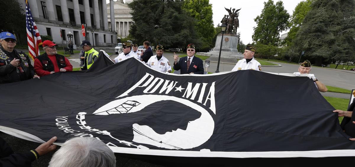 A large POW/MIA flag is displayed during a ceremony at Washington state's POW-MIA memorial, Friday, Sept. 20, 2013, in Olympia, Wash.  The event honored people who have been prisoners of war and those who are still missing in action. The Olympia event was one of many held nationally.  The flag used to fly at the Kingdome in Seattle. (AP Photo/Ted S.