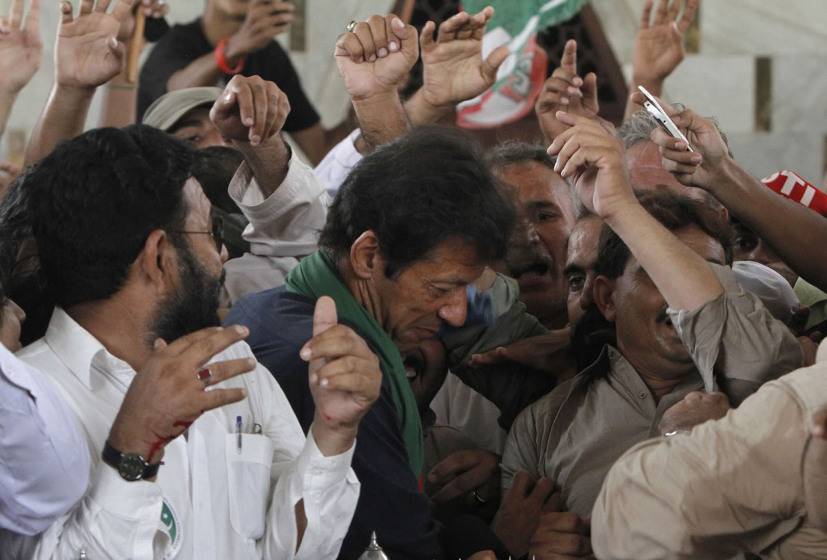 Pakistan's cricket star-turned-politician Imran Khan is surrounded by his supporters during an election rally in Karachi, Pakistan on Tuesday.