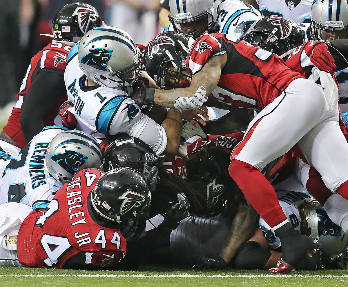 Carolina Panthers quarterback Cam Newton is swarmed by Atlanta Falcons defenders during the second half of an NFL football game on Sunday, Dec. 27, 2015, in Atlanta.