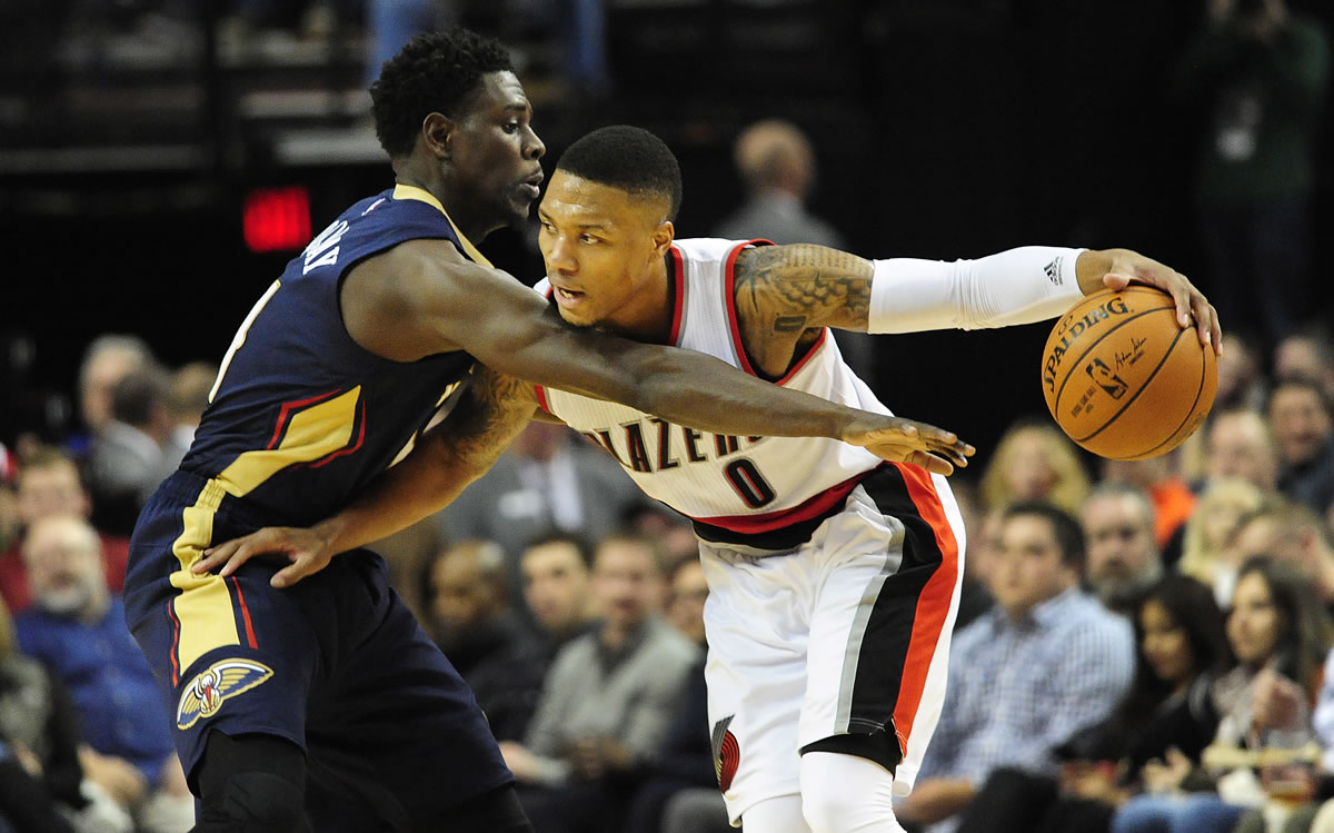 New Orleans&#039; Jrue Holiday, left, defends Portland&#039;s Damian Lillard (0) during the second half Monday.
