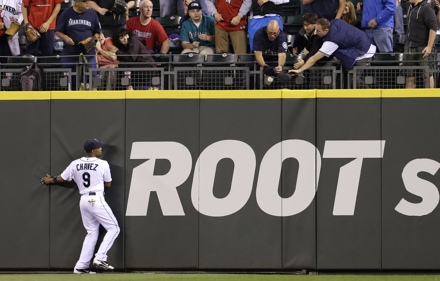 Seattle Mariners center fielder Endy Chavez watches as fans reach for the home run ball of Pittsburgh Pirates' Russell Martin in the second inning Tuesday.