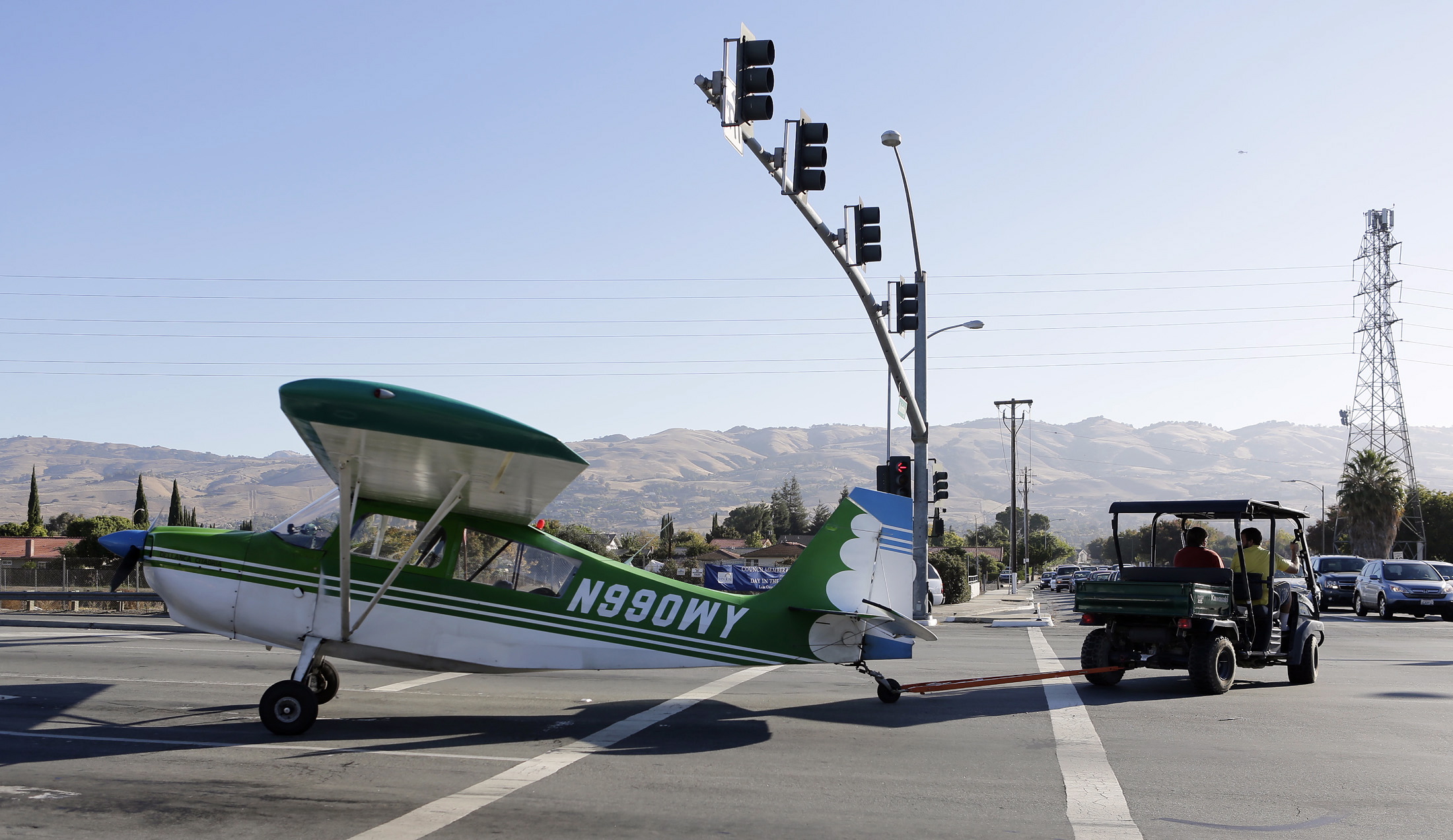 A small plane is towed away from the Capitol Expressway in San Jose, Calif., after making an emergency landing.
