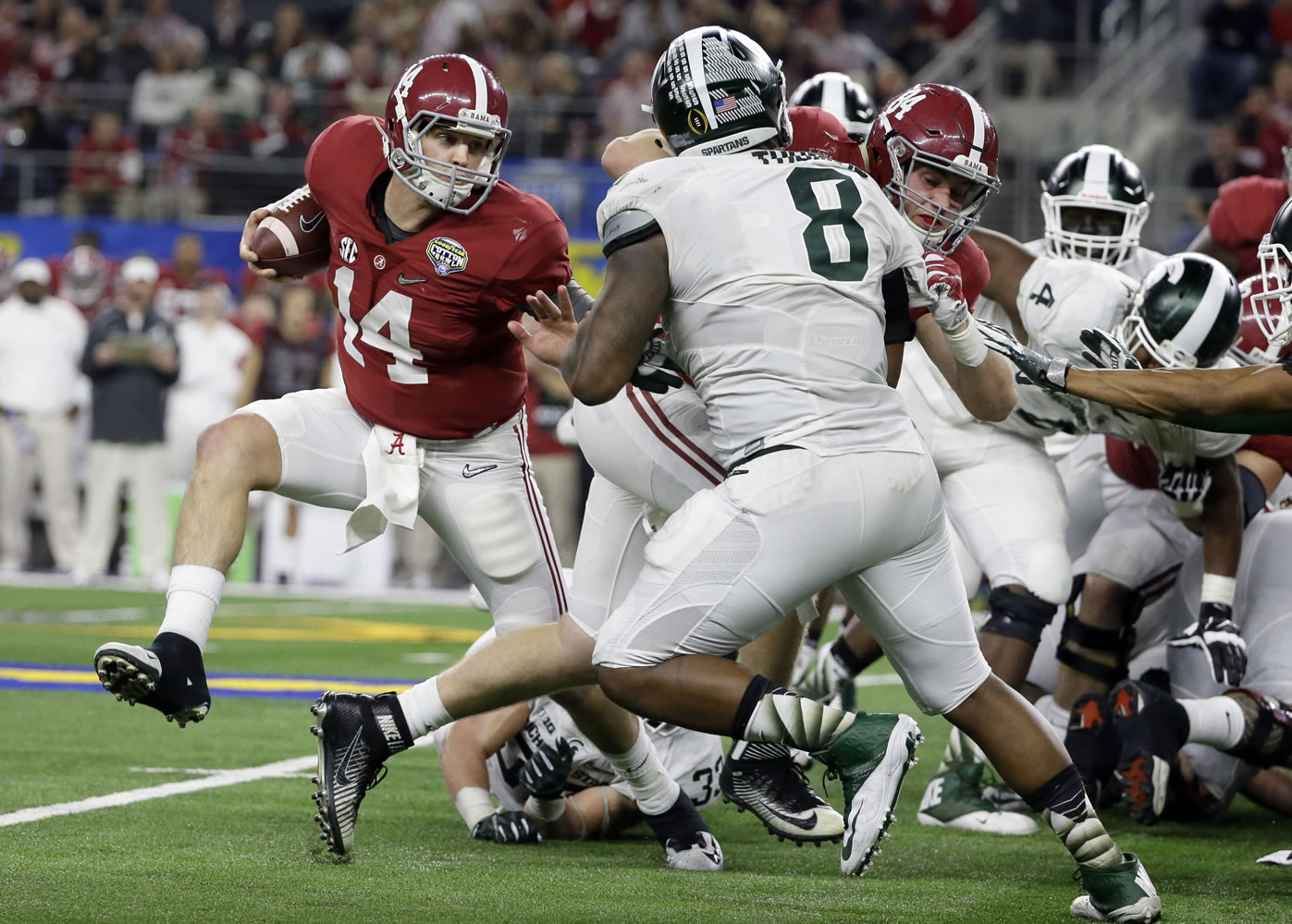 Alabama quarterback Jake Coker (14) tries to escape Michigan State defense during the second half of the Cotton Bowl NCAA college football semifinal playoff game, Thursday, Dec. 31, 2015, in Arlington, Texas.