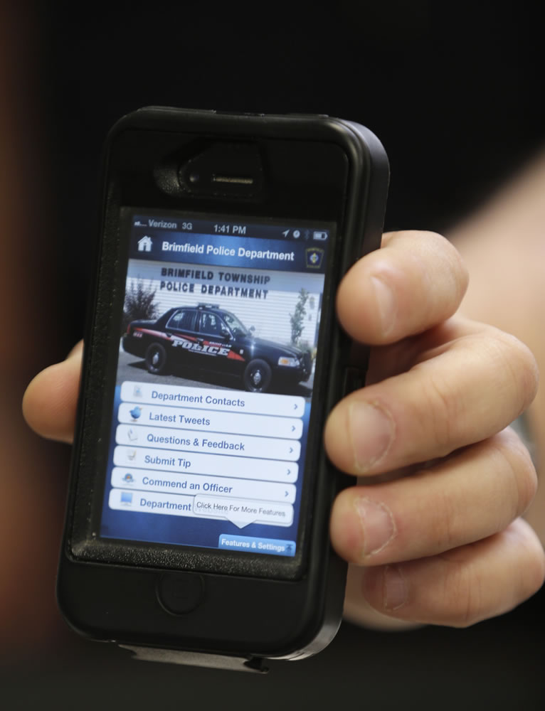 Brimfield Police Chief David Oliver holds up his cell phone with the Brimfield Township police department website shown in Kent, Ohio.