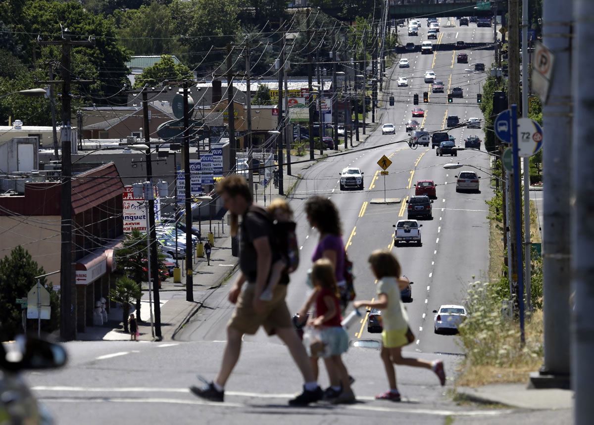 Pedestrians cross 82nd Avenue in East Portland on July 14. The avenue is traditionally considered the dividing line between Portland and East Portland, where shabby apartment complexes, fading strip malls, wide avenues and fast-food chains are the norm.