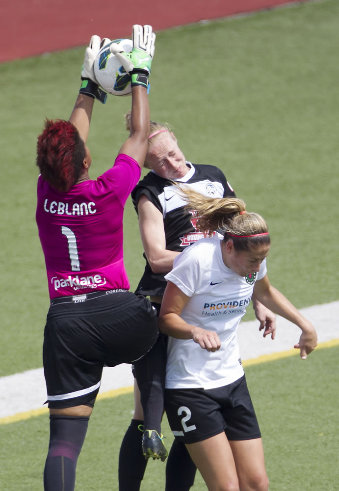 Kansas City's Becky Sauerbrunn, center, is unable to head the ball past Portland goalkeeper Karina LeBlanc, left, as Portland's Marian Dougherty helps to defend during Saturday's playoff game.