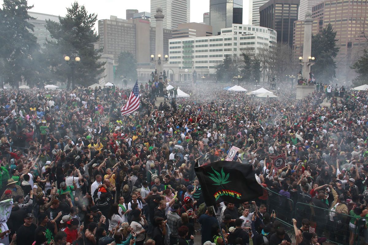 Members of a crowd numbering tens of thousands smoke marijuana simultaneously at 4:20 PM, at the Denver 420 pro-marijuana rally at Civic Center Park in Denver on Saturday.