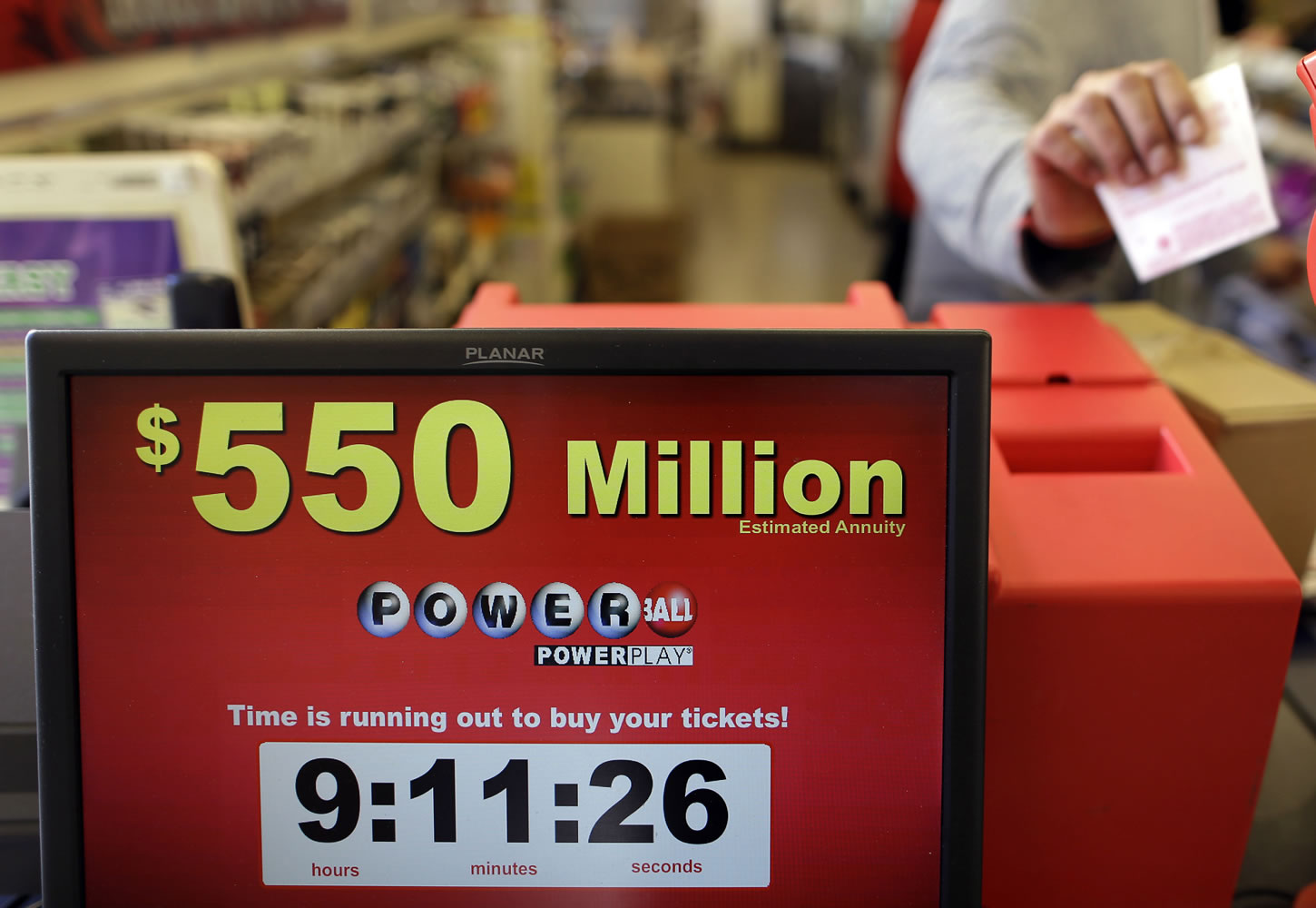 Store clerk Keyur Patel pulls a Powerball ticket that was dispensed from a machine in a convenience store in Baltimore on Wednesday. There have been no Powerball winners since Oct.