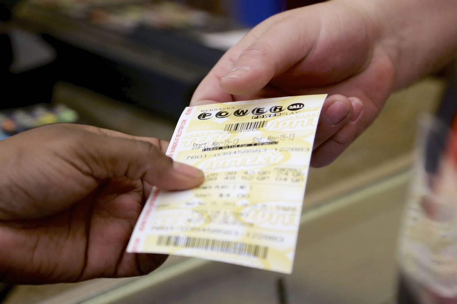 A customer receives her Powerball ticket supermarket in Omaha, Neb., on Wednesday.