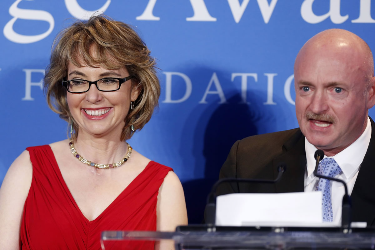 Capt. Mark Kelly speaks next to his wife, former Arizona Congresswoman Gabrielle Giffords, after she received the John F.