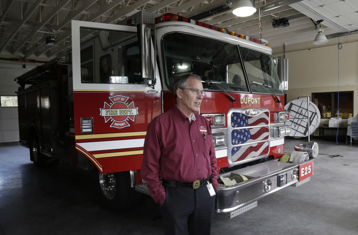 DuPont Fire Chief Greg Hull stands near a fire engine March 20 in the fire department garage. Hull received a substantial pay raise from Lakewood Fire District No. 2 just before he retired, which increased his annual pension -- paid from a state-run fund, not directly by the fire district -- to $184,000.