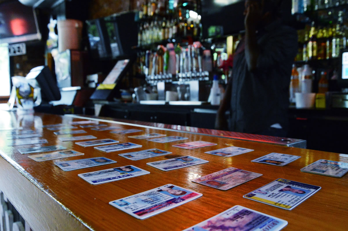 Fake IDs confiscated from would-be customers are displayed on the Stubblefields bar in Pullman.