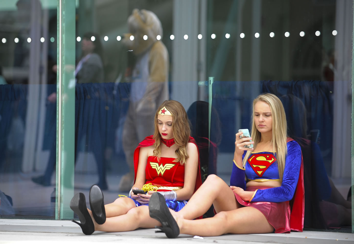 Denis Poroy/Invision
Joy Donaldson, left, dressed as Wonder Woman, and Everleigh Reed, dressed as Supergirl, take a break July 28 at the 2013 Comic-Con International Convention in San Diego.