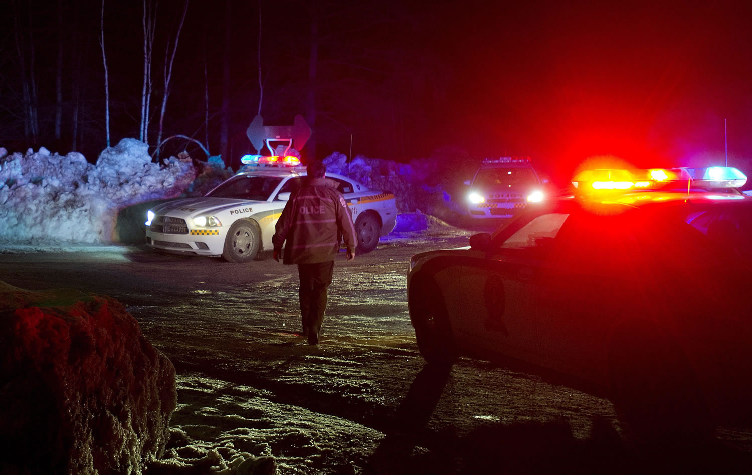Police vehicles block a road just outside the town of Chertsey, Quebec, on Sunday during a search for escaped prisoners.