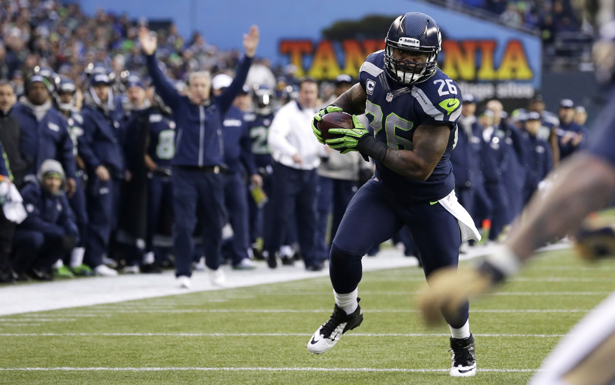 Seattle Seahawks' Michael Robinson heads for the end zone as Seahawks head coach Pete Carroll signals the touchdown in the background during the third quarter Sunday.