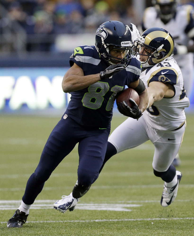 Seattle Seahawks wide receiver Golden Tate (81) runs the ball ahead of St. Louis Rams strong safety Craig Dahl, right, during the second half.