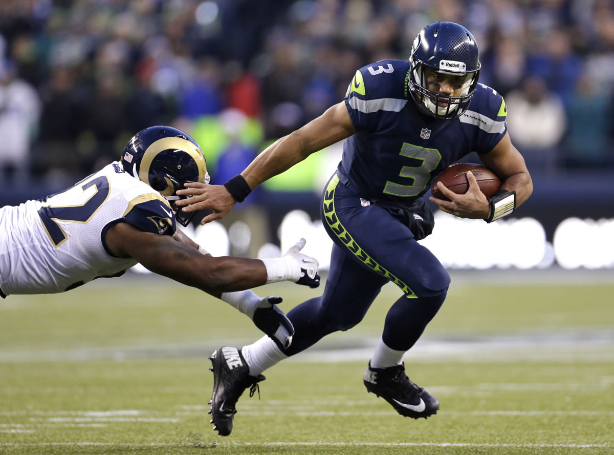 Seattle Seahawks quarterback Russell Wilson (3) pushes past St. Louis Rams' Eugene Sims for a 15-yard run in the second half of an NFL football game, Sunday, Dec. 30, 2012, in Seattle. The Seahawks won 20-13.
