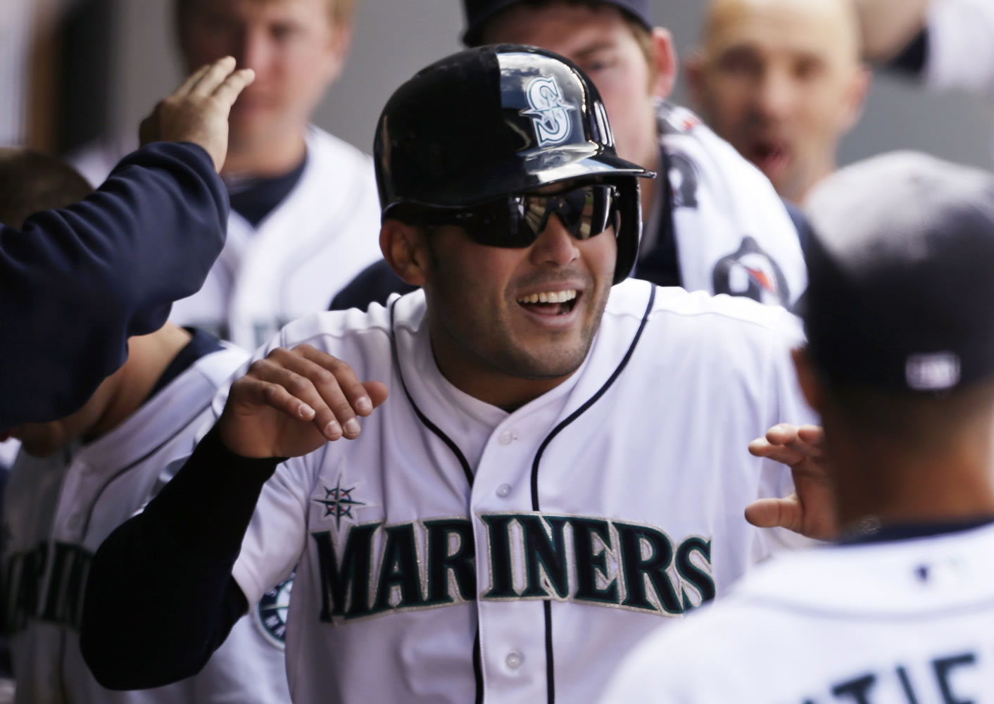 Seattle Mariners' Jesus Montero is congratulated after scoring the tie-breaking run against the Texas Rangers in the sixth inning Sunday.