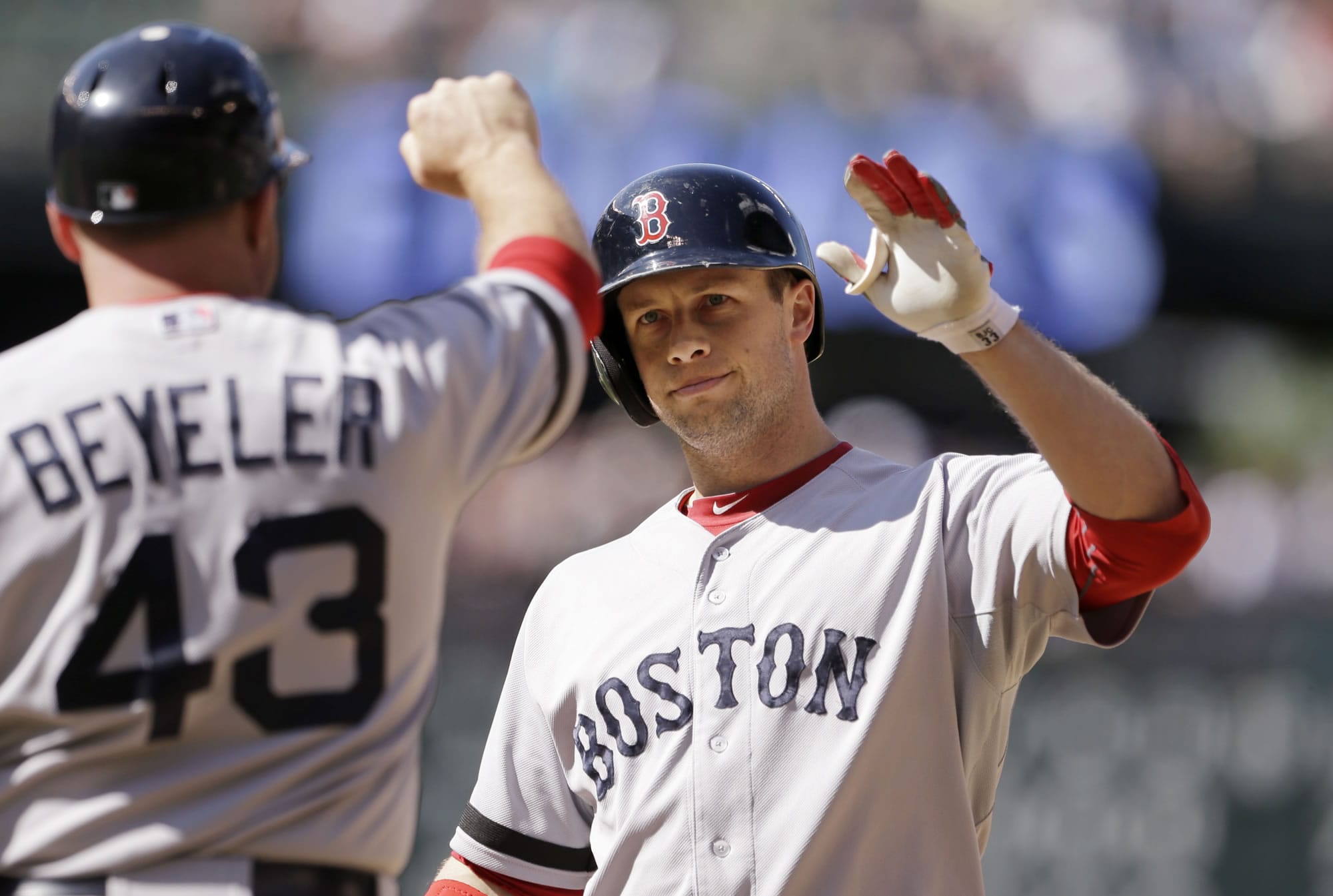 Boston Red Sox's Daniel Nava, right, is congratulated by first base coach Arnie Beyeler after hitting an RBI-single against the Seattle Mariners in the 10th inning Thursday.