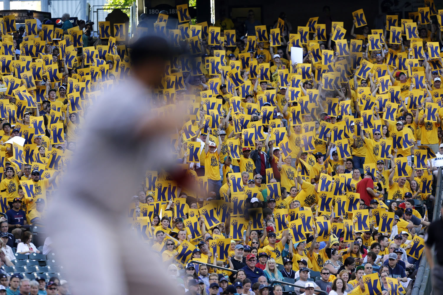 Fans in the &quot;King's Court&quot; special cheering section for Seattle Mariners starting pitcher Felix Hernandez hold up &quot;K cards&quot; calling for a strikeout as Boston Red Sox batter Jonny Gomes waits for a pitch in the first inning.
