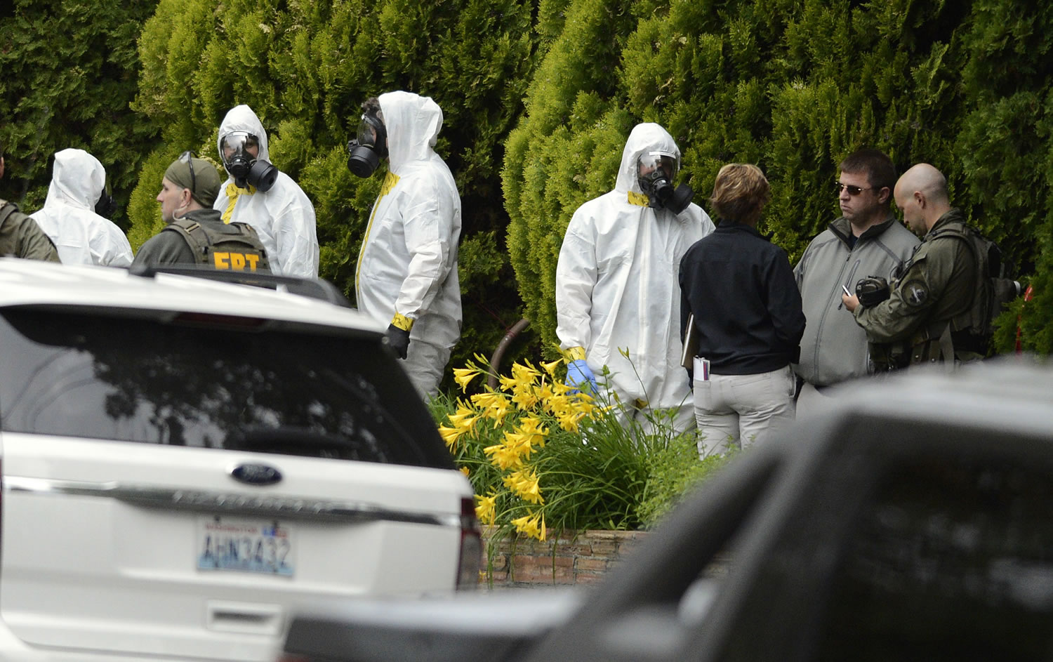 Members of the Joint Federal Haz-Mat Team, FBI, and local law enforcement gather outside a three-story apartment building Saturday in Spokane to execute a search warrant connection with two ricin-laced letters intercepted Tuesday at a post office.