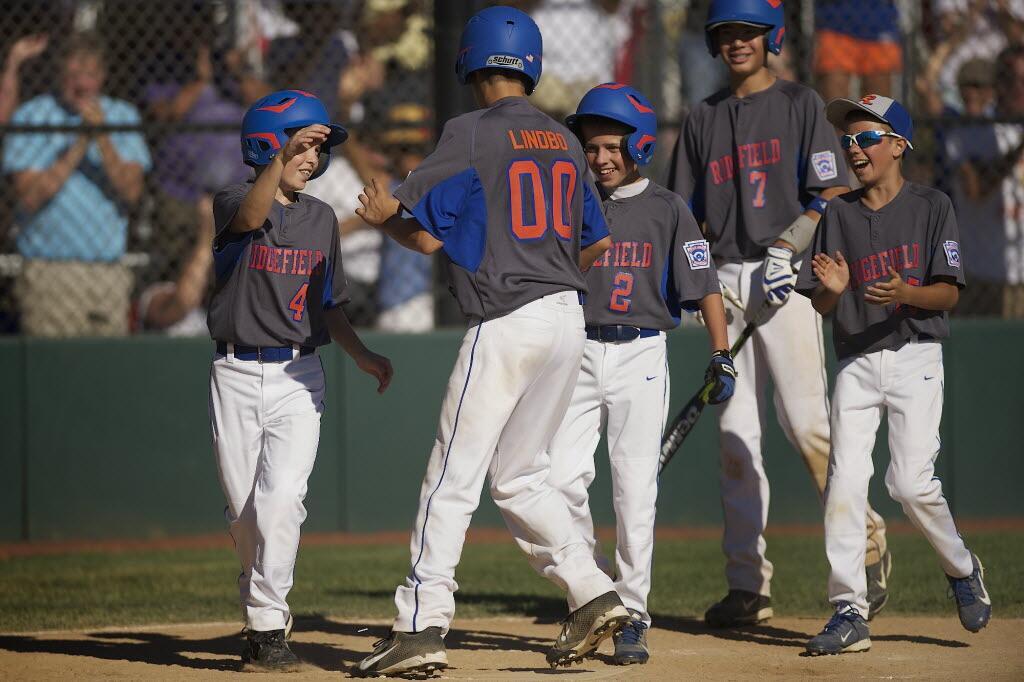 Ridgefield's Joe David Lindbo (00) celebrates with teammates after hitting a home run in Monday's game at the Washington State Little League tournament at Luke Jensen Sports Park in Vancouver.
