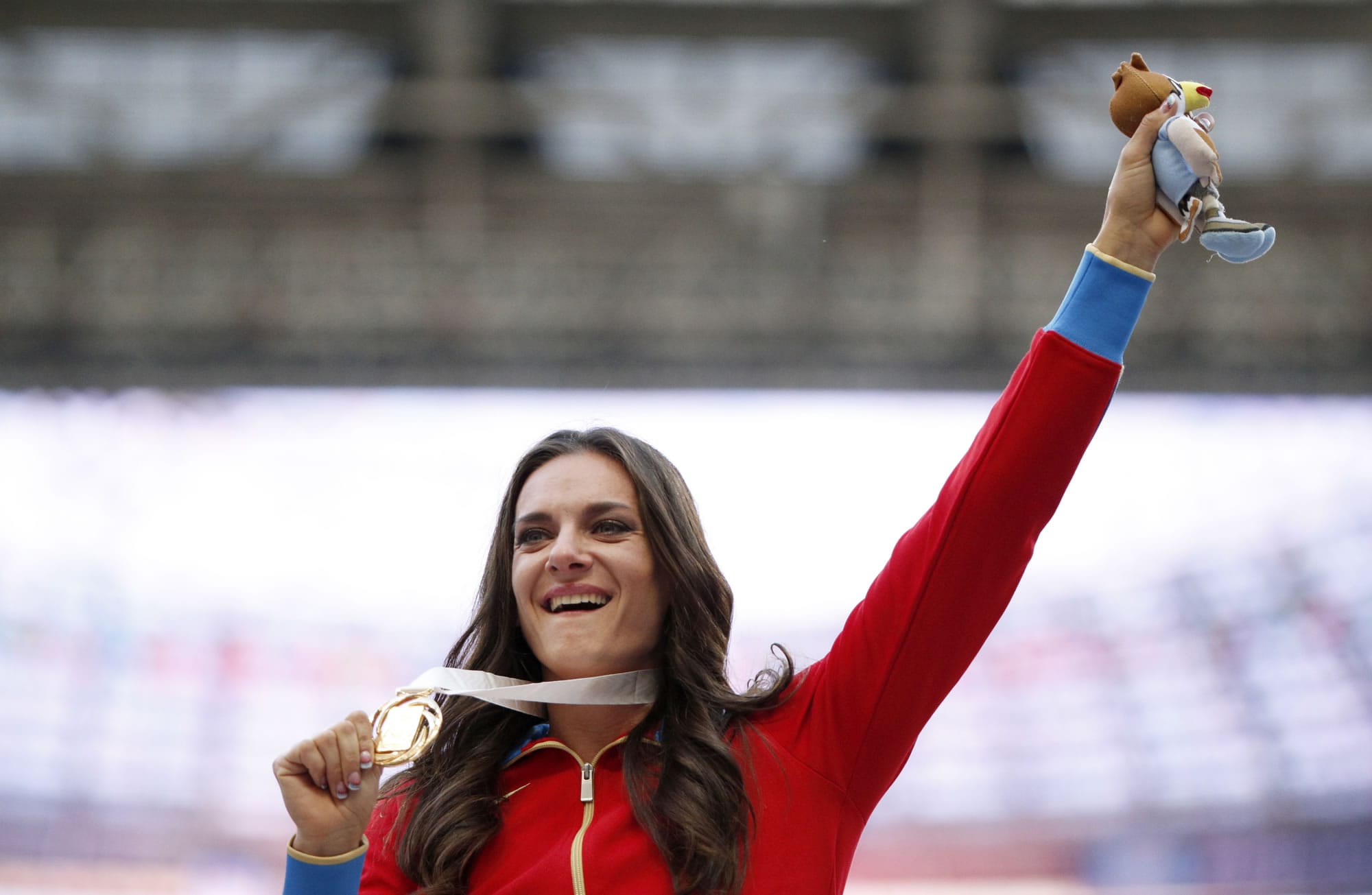 Russia's Yelena Isinbayeva gestures to the crowd with her gold medal in the women's pole vault as she stands on the podium during the medal ceremony at the World Athletics Championships in the Luzhniki stadium in Moscow on Thursday.