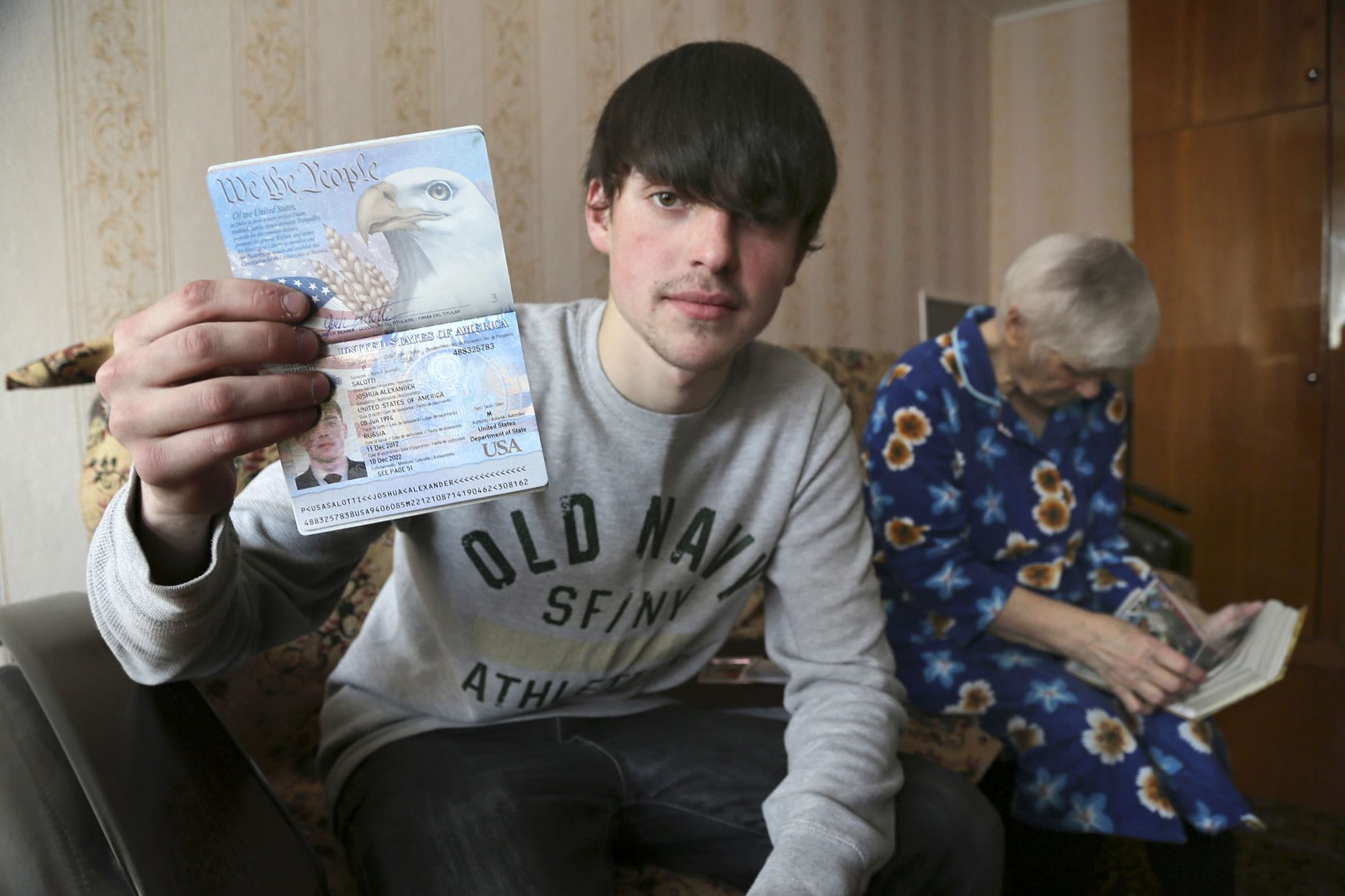 Alexander Abnosov shows his American passport to journalists in the Volga river city of Cheboksary, Russia.