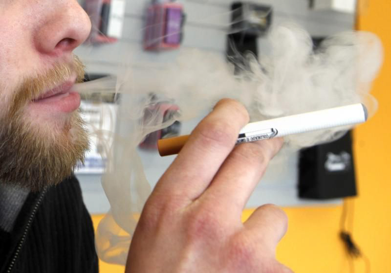 A sales associate demonstrates the use of a electronic cigarette and the smoke like vapor that comes from it in Aurora, Colo., in 2011.