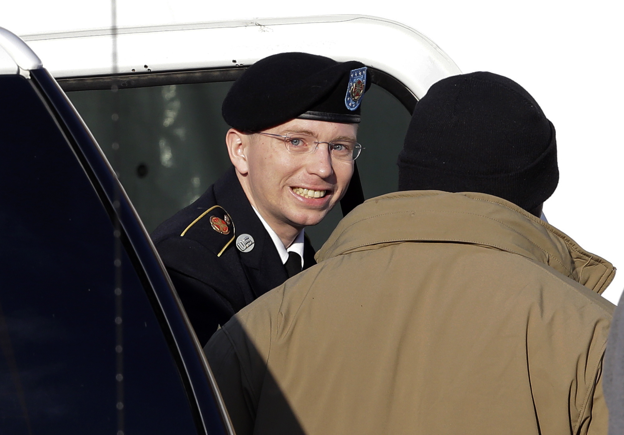 Army Pfc. Bradley Manning, center, steps out of a security vehicle as he is escorted into a courthouse in Fort Meade, Md., on Nov.