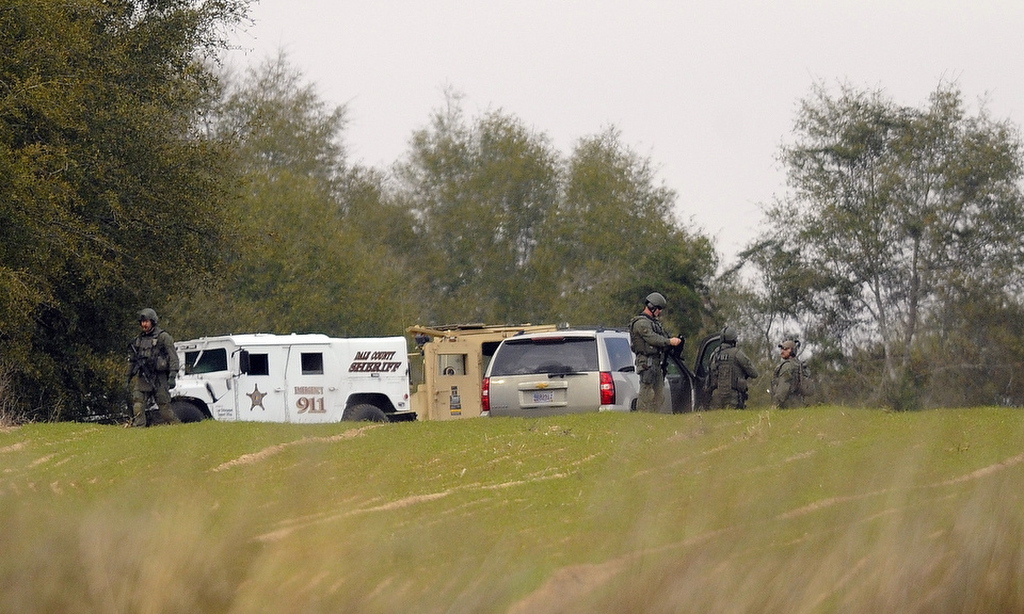 Armed law enforcement personnel station themselves near the property of Jimmy Lee Dykes on Monday in Midland City, Ala. Officials say they stormed a bunker in Alabama to rescue a 5-year-old child being held hostage there after Dykes, his abductor, was seen with a gun.