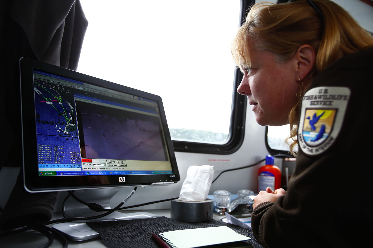 Sue Thomas, a wildlife biologist with the U.S. Fish and Wildlife Service, monitors the video feed coming from the Puma drone on the RV Tatoosh on June 28.