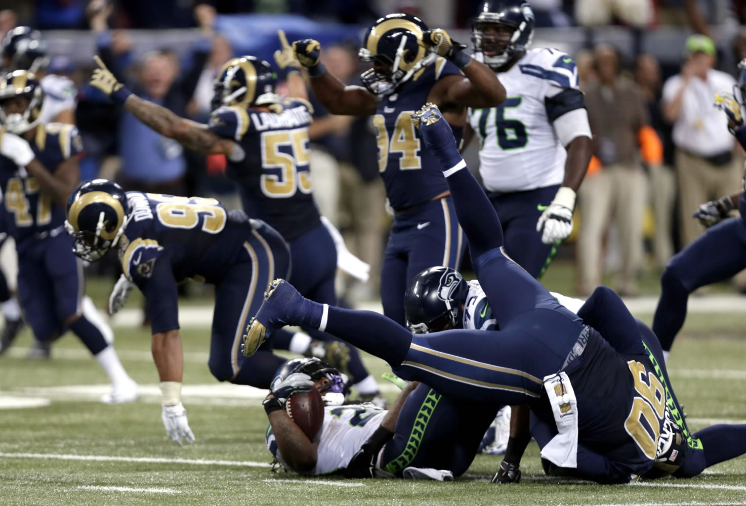Seattle Seahawks running back Marshawn Lynch lands on his back as he is stopped on fourth down and St. Louis Rams players celebrate on the final play in overtime on Sunday, Sept. 13, 2015, in St. Louis. The Rams won 34-31.