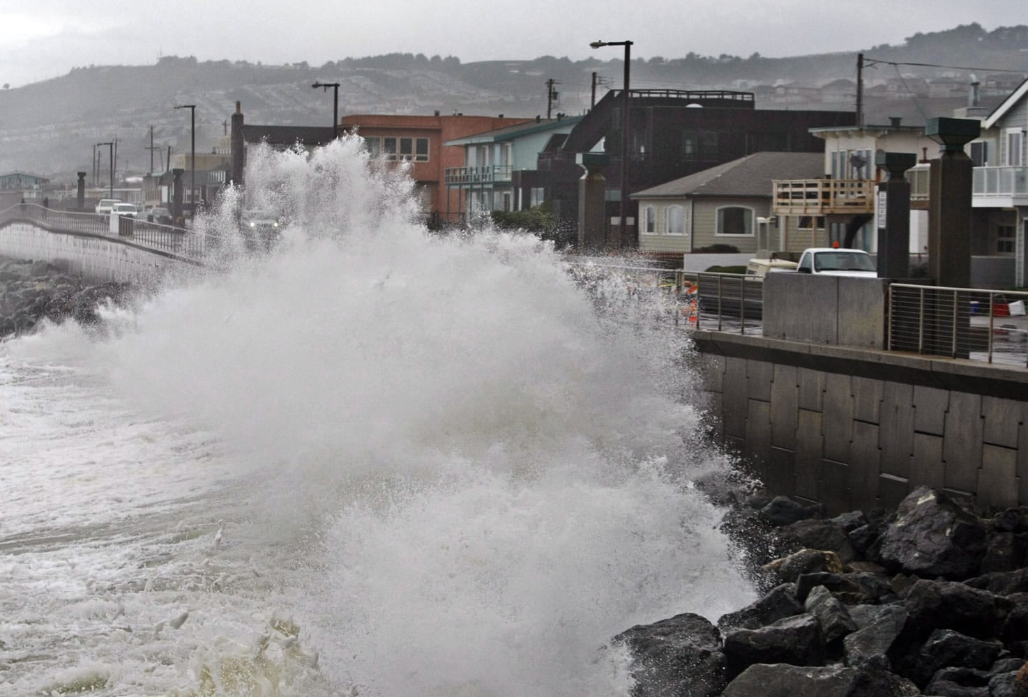 Waves pound a wall near buildings in Pacifica, Calif., during a rain storm in 2010.