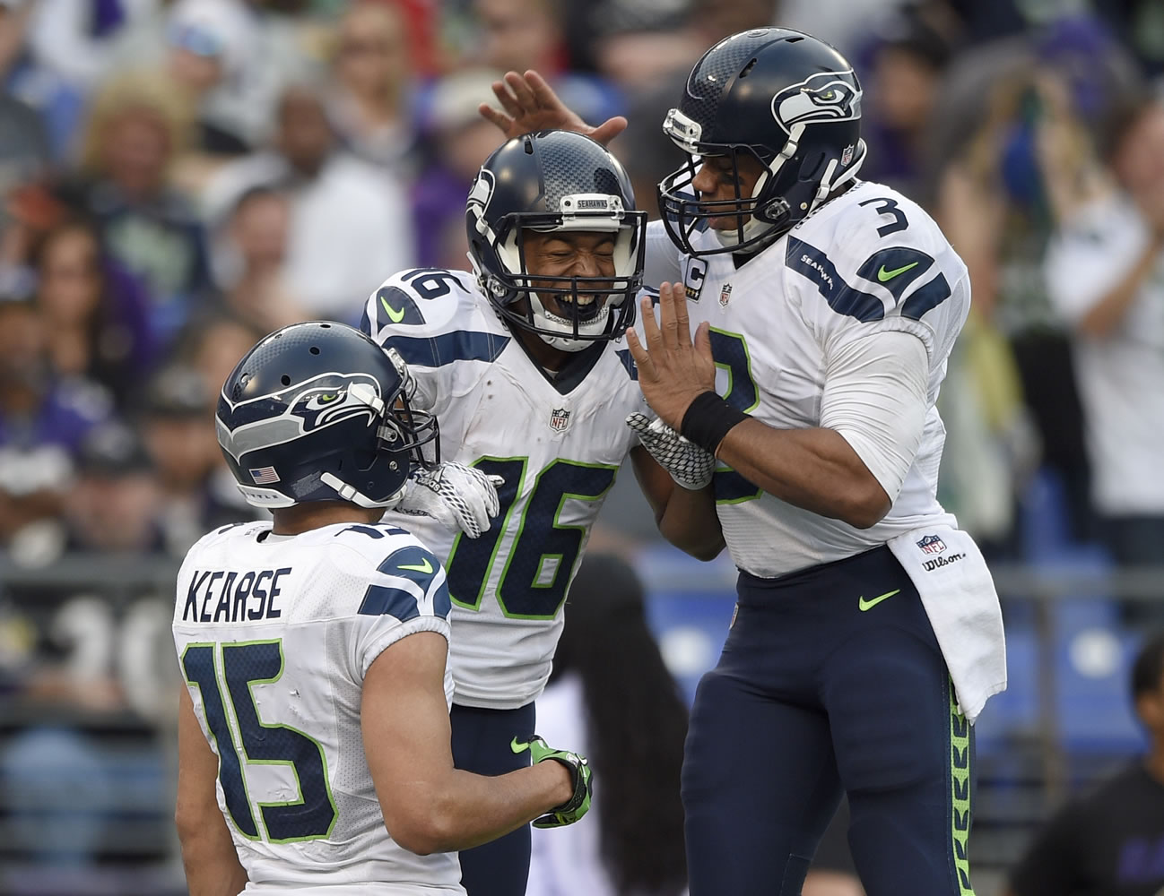 Seattle Seahawks wide receiver Jermaine Kearse (15) watches as Seahawks wide receiver Tyler Lockett (16) and Seahawks quarterback Russell Wilson (3) celebrate connecting for a touchdown during the second half an NFL football game against the Baltimore Ravens, Sunday, Dec. 13, 2015, in Baltimore.