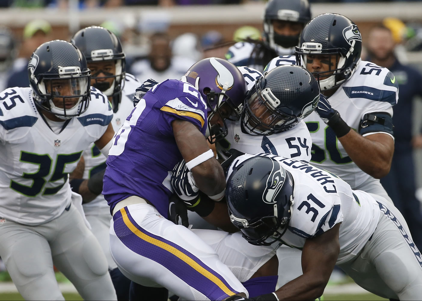 Vikings running back Adrian Peterson (28) is stopped by Seahawks defenders including  Bobby Wagner (54) and Kam Chancellor (31).