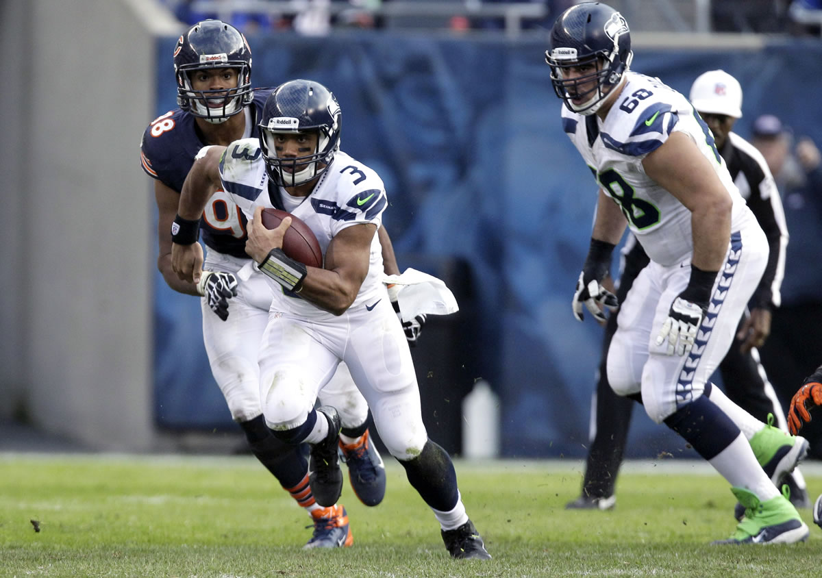 Seattle Seahawks quarterback Russell Wilson (3) rushes past Chicago Bears defensive end Corey Wootton (98) during the second half Sunday.