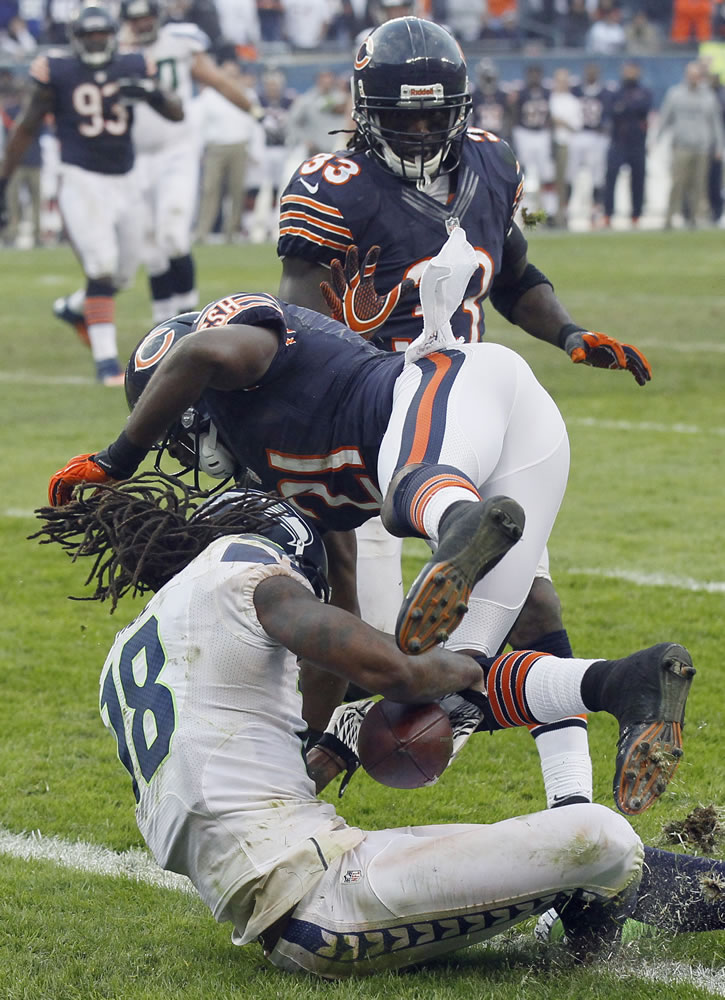 Seattle Seahawks wide receiver Sidney Rice (18) falls into the end zone for the game-winning touchdown in overtime after being hit by Chicago Bears safety Major Wright (21).