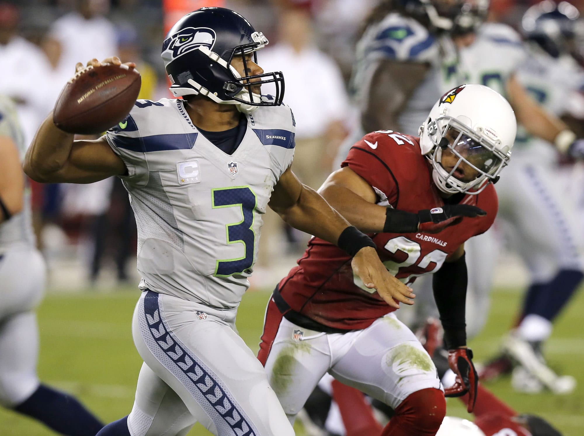 Seattle Seahawks quarterback Russell Wilson (3) scrambles as Arizona Cardinals free safety Tyrann Mathieu defends during the first half of an NFL football game, Thursday, Oct. 17, 2013, in Glendale, Ariz. (AP Photo/Ross D.
