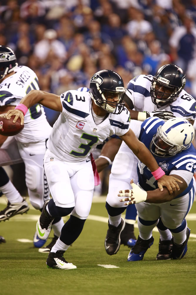 Seattle Seahawks quarterback Russell Wilson, left, breaks away from Indianapolis Colts nose tackle Aubrayo Franklin during the first half Sunday.