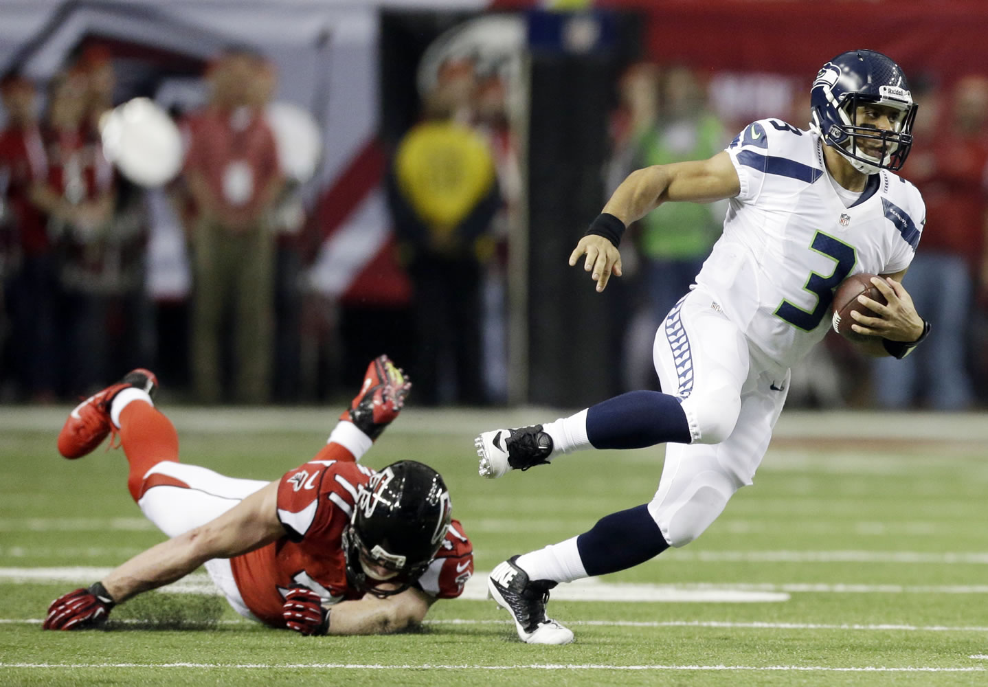Seattle Seahawks quarterback Russell Wilson (3) runs past Atlanta Falcons defensive end Kroy Biermann (71) during the first half Sunday.