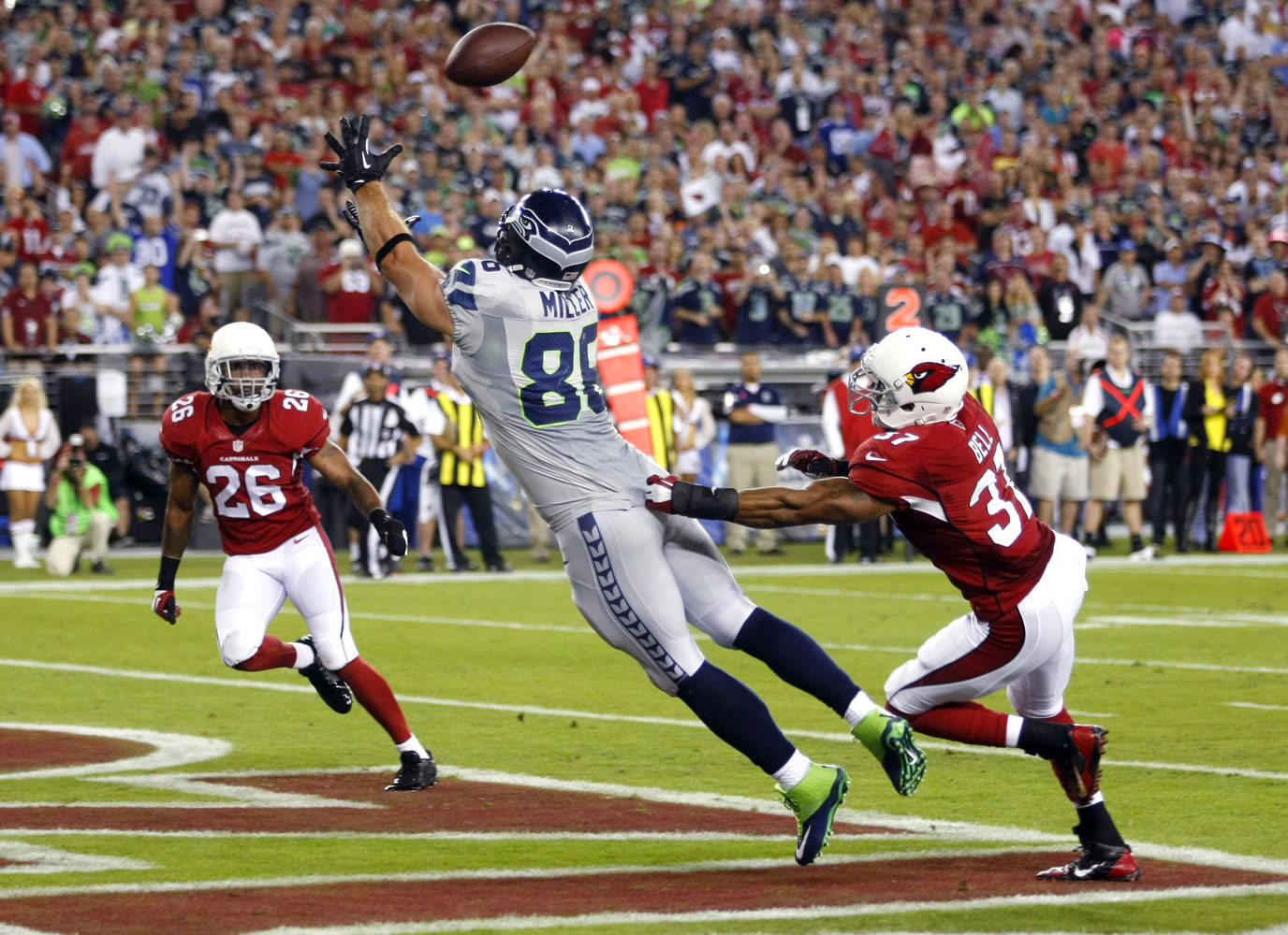 Seattle Seahawks tight end Zach Miller (86) pulls in a touchdown pass as Arizona Cardinals strong safety Yeremiah Bell (37) and Rashad Johnson (26) defend during the first half on Thursday, Oct. 17, 2013, in Glendale, Ariz.