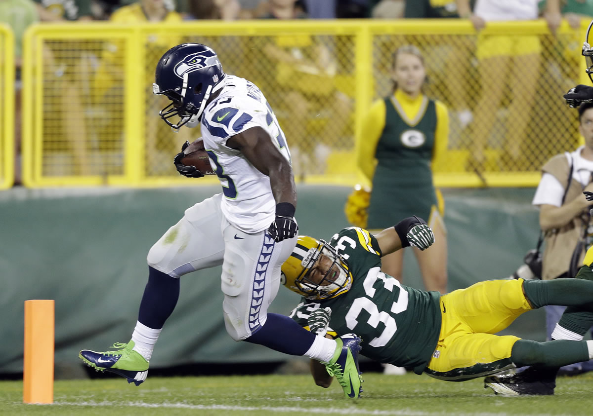 Seattle Seahawks' Christine Michael reaches the end zone as he breaks away from Green Bay Packers' Micah Hyde to complete a 43-yard touchdown run Friday.