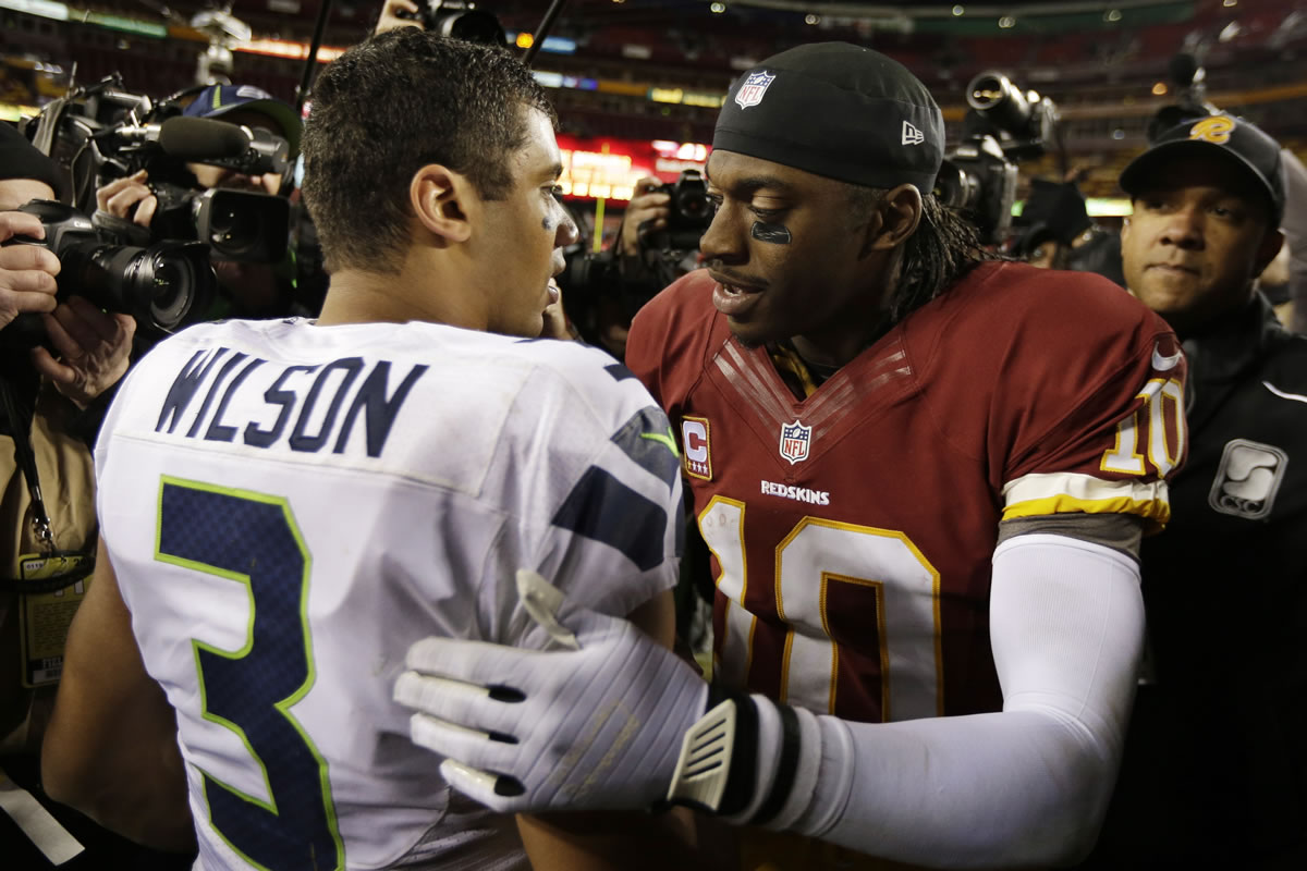 Seattle Seahawks quarterback Russell Wilson greets Washington Redskins quarterback Robert Griffin III after an NFL wild card playoff football game in Landover, Md., Sunday.