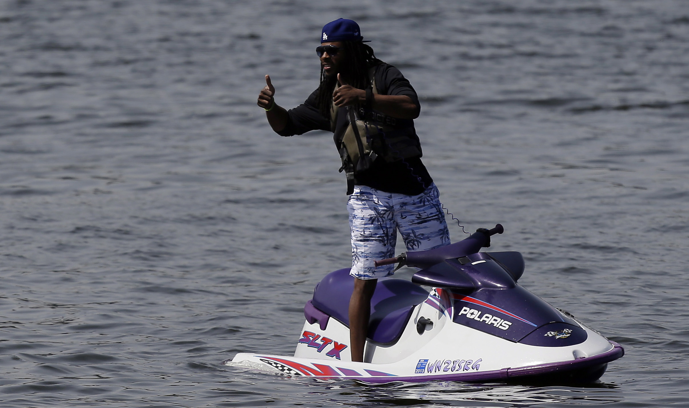 Seattle Seahawks cornerback Richard Sherman give an approving thumbs up from a personal watercraft on Lake Washington.