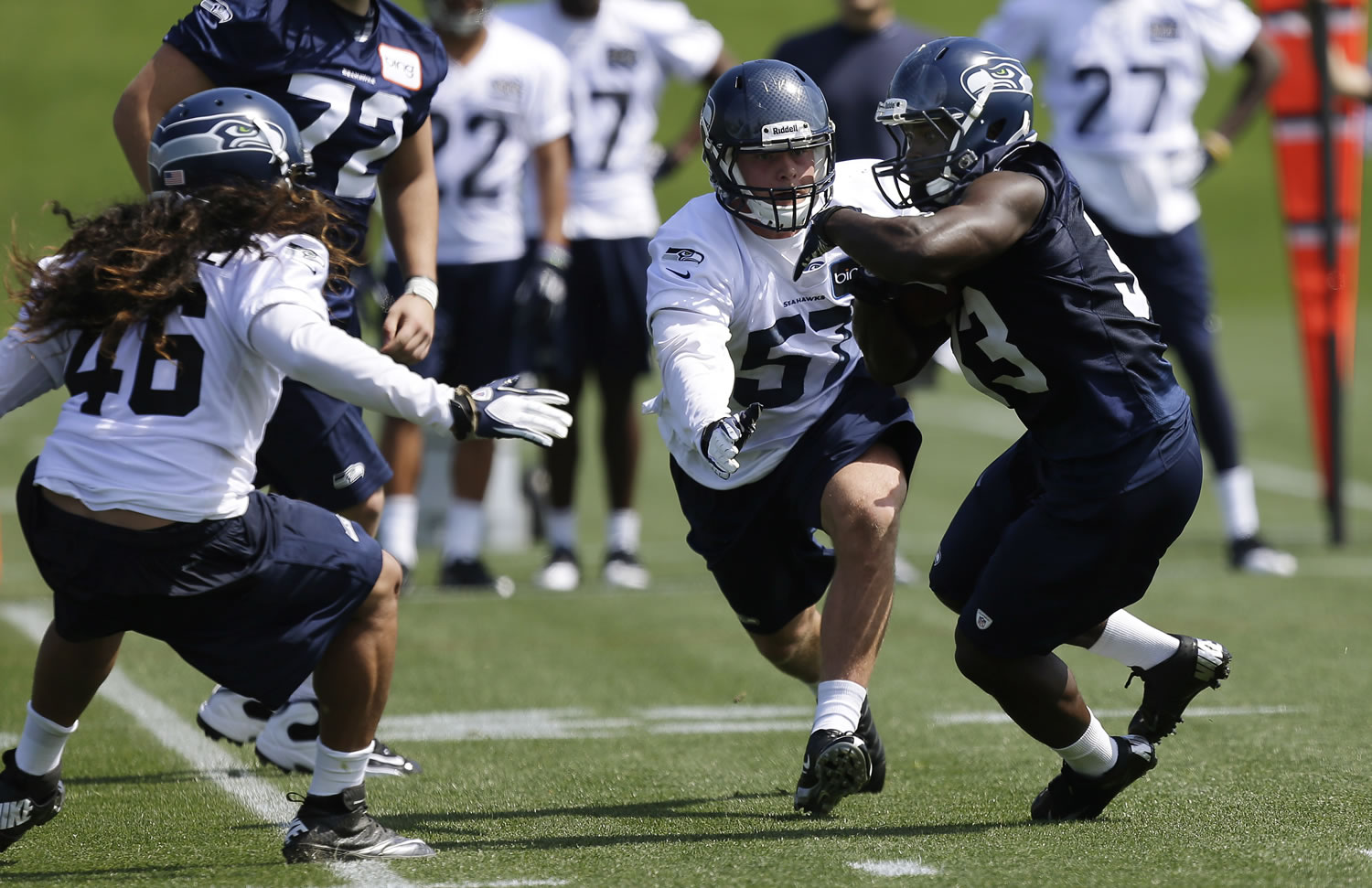 Seattle Seahawks top draft pick, running back Christine Michael, right, tries to avoid the defense of Seahawks' John Lotulelei, left, and Jaydan Bird, second from right, during practice drills Friday.