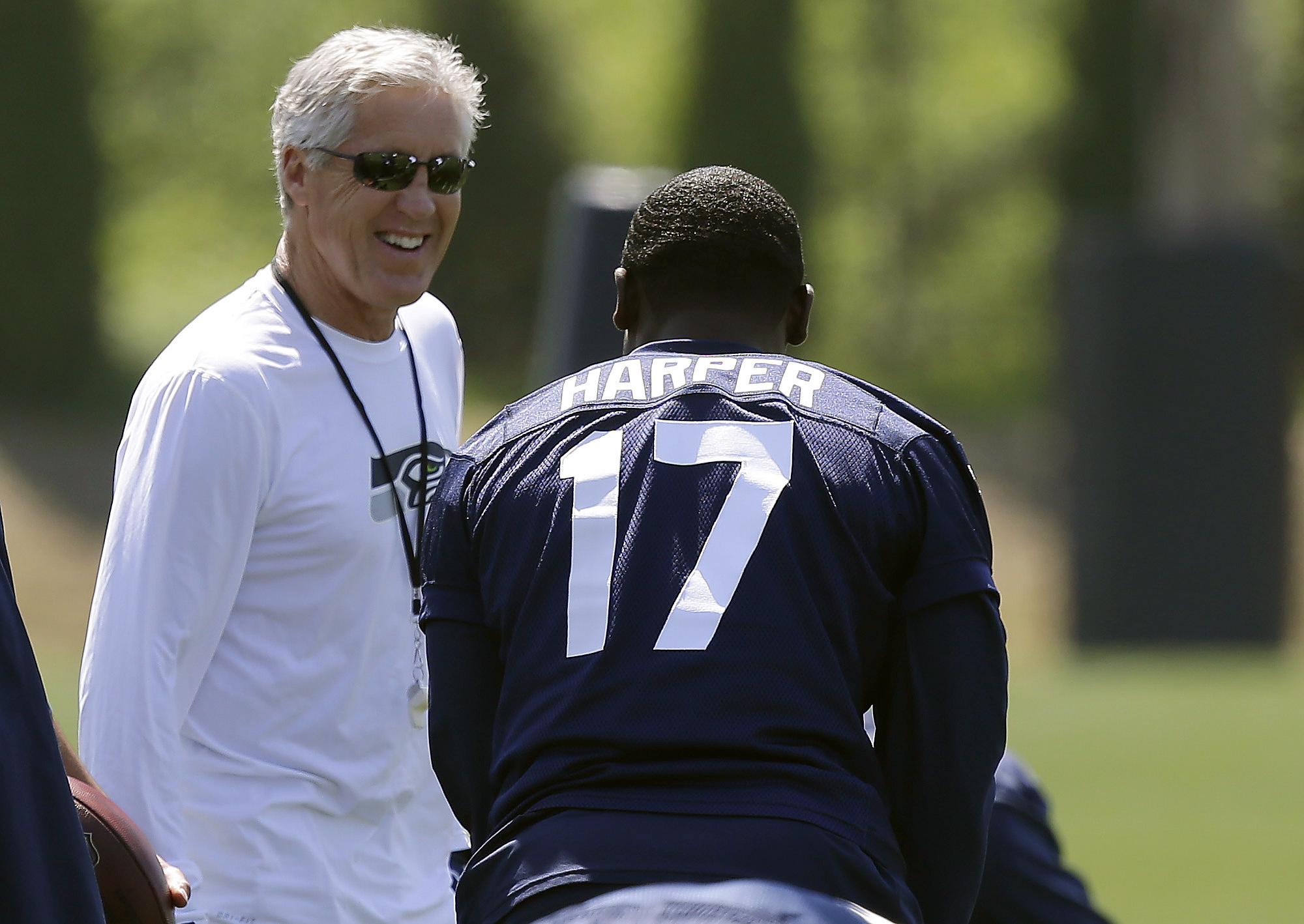 Seattle Seahawks head coach Pete Carroll, left, talks to Chris Harper during minicamp drills Friday at Renton.