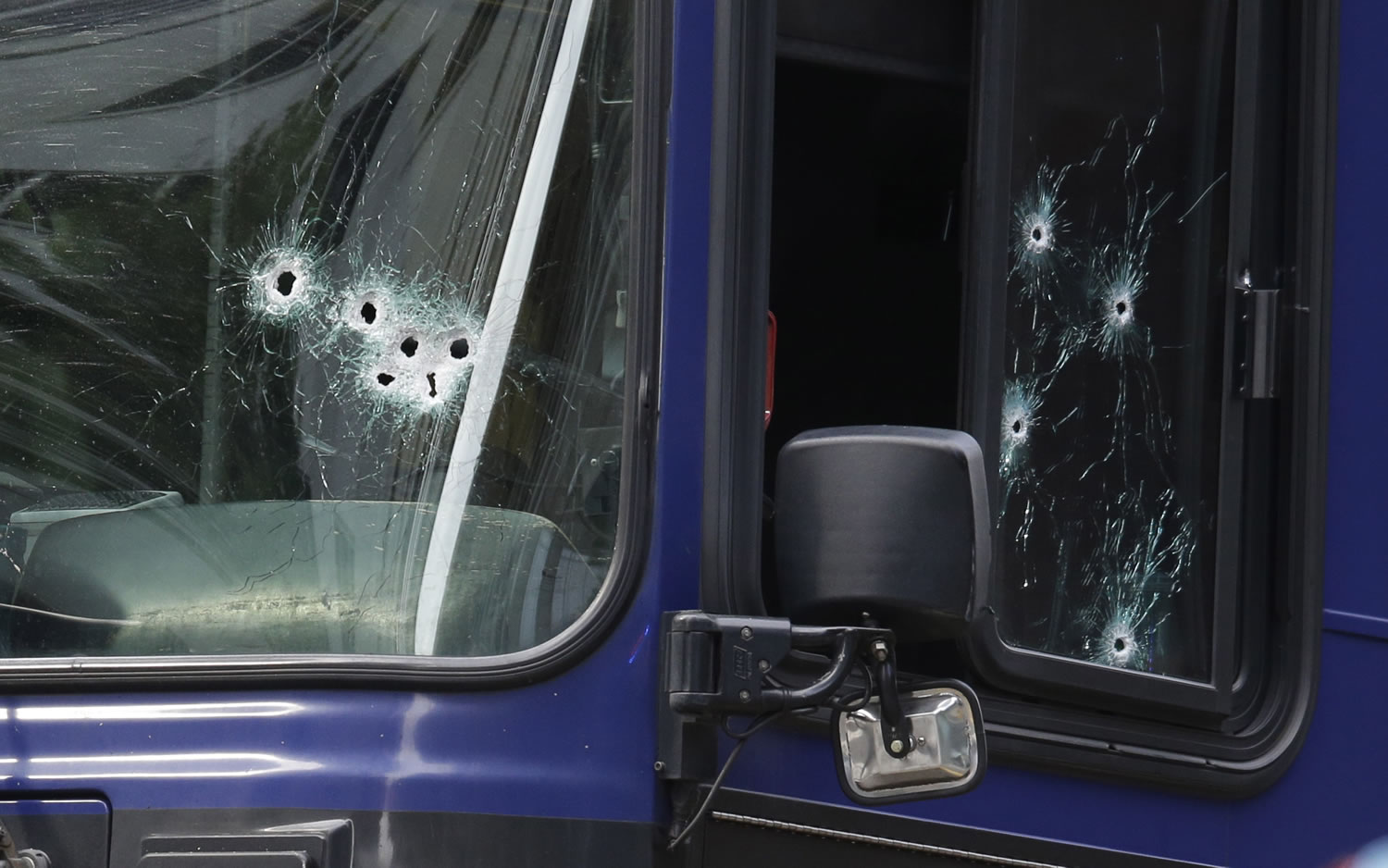A King County Metro bus with multiple bullet holes in its windshield and side window is seen in downtown Seattle after a bus driver was shot Monday.