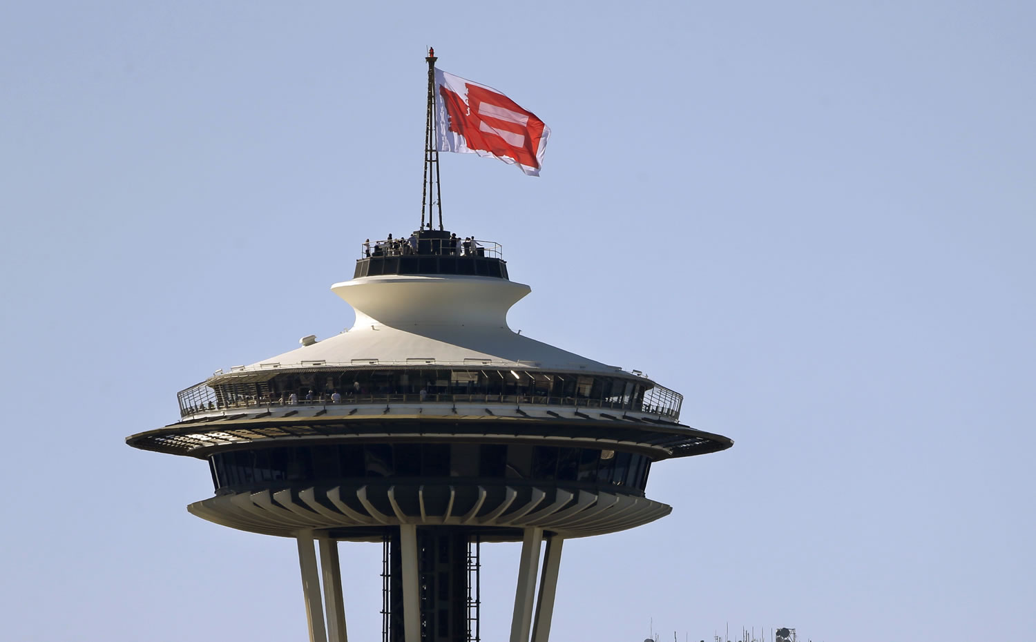 A giant marriage equality flag, with an &quot;equal&quot; symbol inside an outline of Washington state, flutters atop the Space Needle on Sunday in Seattle.